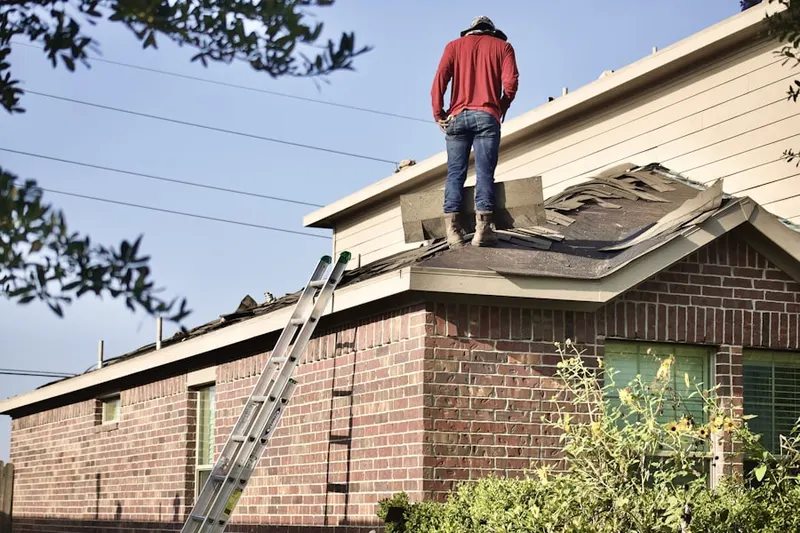 Professional roofer working on a residential roof in New York Avenue